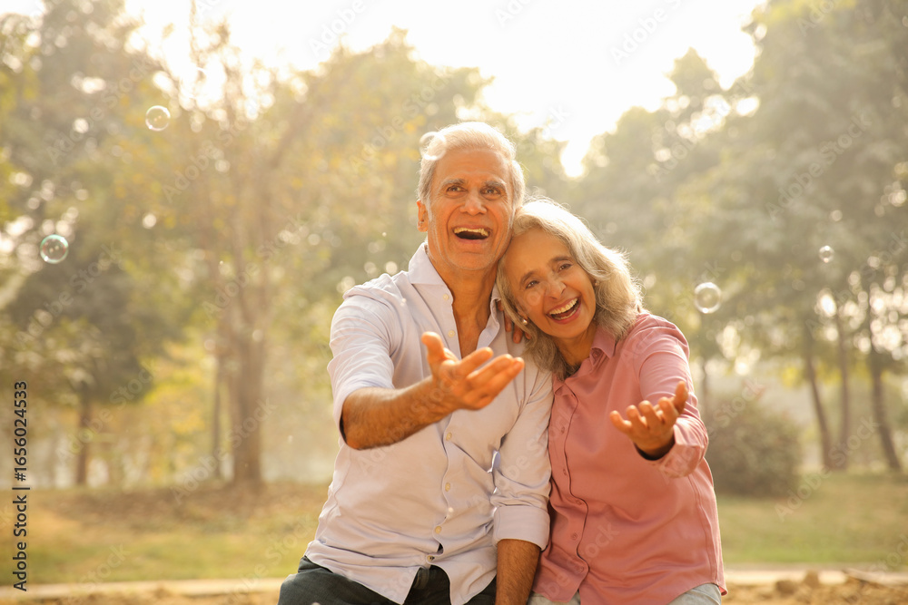 Fototapeta premium Seniors Enjoying Time Together And Playing With Bubbles