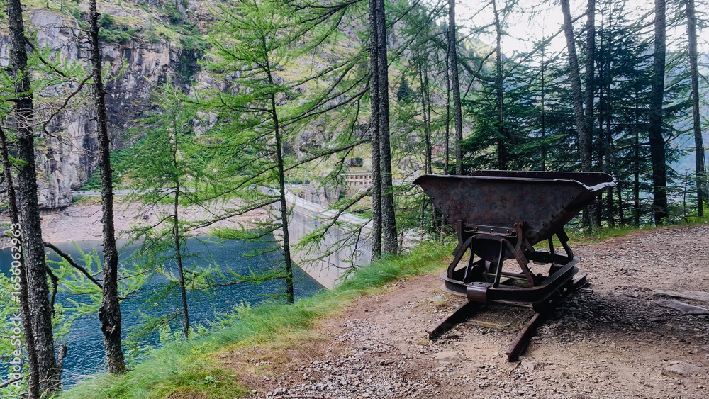 Naklejka premium Old rail trolley on an abandoned trail around Lake Campliccioli, Antrona Valley, Piedmont, Italy.