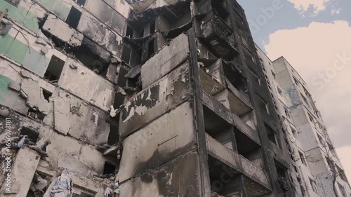 Borodyanka, Ukraine - 05 15 2022: Ruins of burnt high-rise residential building in Kyiv region after artillery shelling. Fragment of facade of house with destroyed walls by explosion.