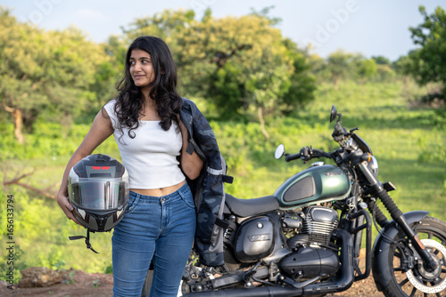Strong independent Indian woman biker: beautiful girl, stylish rider, motorcycle adventure, elegant jacket, confident posture, powerful machine, free spirit, road journey, fearless attitude.