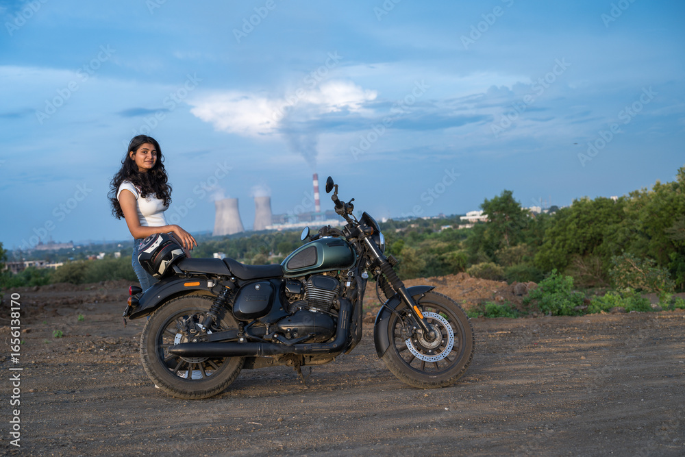 Obraz premium Strong independent Indian woman biker: beautiful girl, stylish rider, motorcycle adventure, elegant jacket, confident posture, powerful machine, free spirit, road journey, fearless attitude.