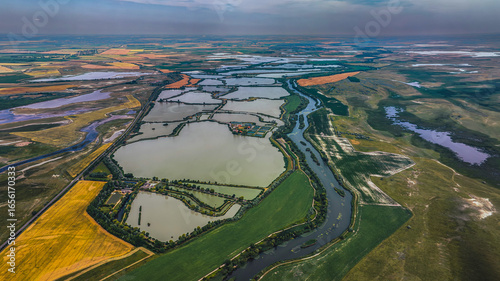 Obraz na płótnie Magnificent drone image showing a network of fishponds and farmlands, representing the harmony of nature and human work