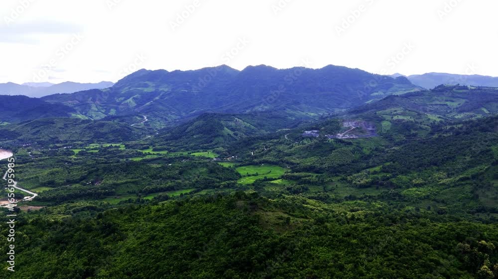 Mountain Vista: A panoramic perspective over rolling mountains, blanketed in lush green, promising serene scenery under a wide sky. Mountain Vista: A panoramic perspective over rolling mountains, blanketed in lush green, promising serene scenery under a wide sky.
