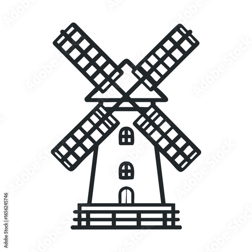 Old windmill with rotating blades in a rural landscape setting