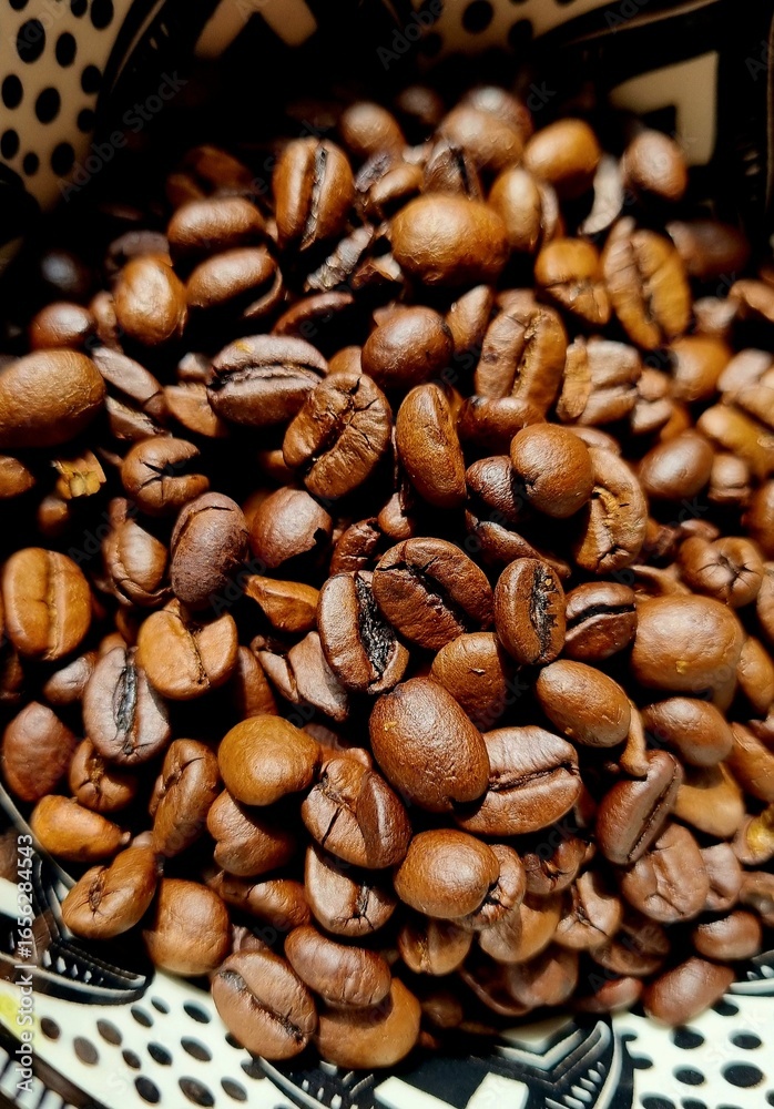 Fototapeta premium Brown coffee beans in the bowl. Close up. 