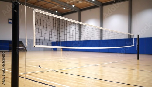 Indoor volleyball court with a wooden floor, marked game lines, and a central net supported by black poles