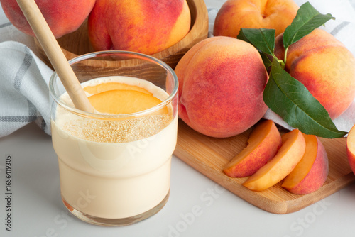 Fresh peaches on the table with a glass of creamy peach yogurt smoothie. Protein shake with peach milkshake. 
