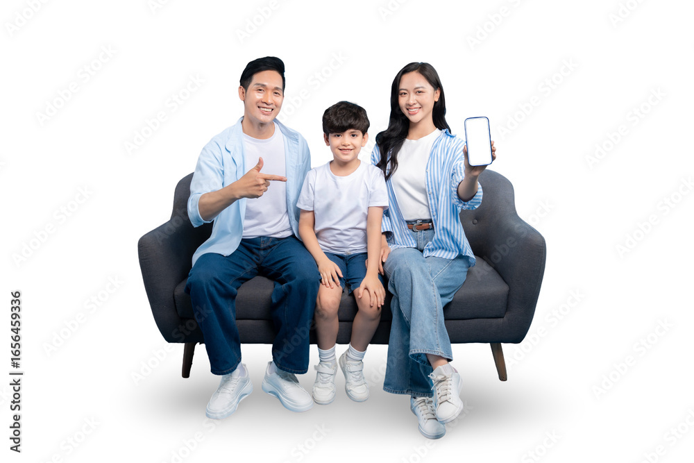 Obraz premium A happy family of three posing on a gray sofa, with mother holding a smartphone showing blank screen on PNG 