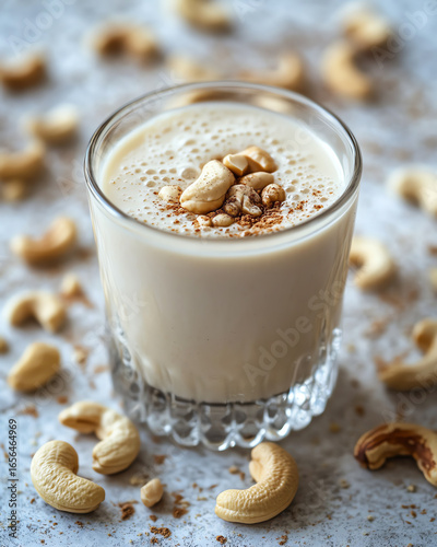 A delicious glass of creamy cashew milk topped with natural cashews, ideal for healthy drink recipes.