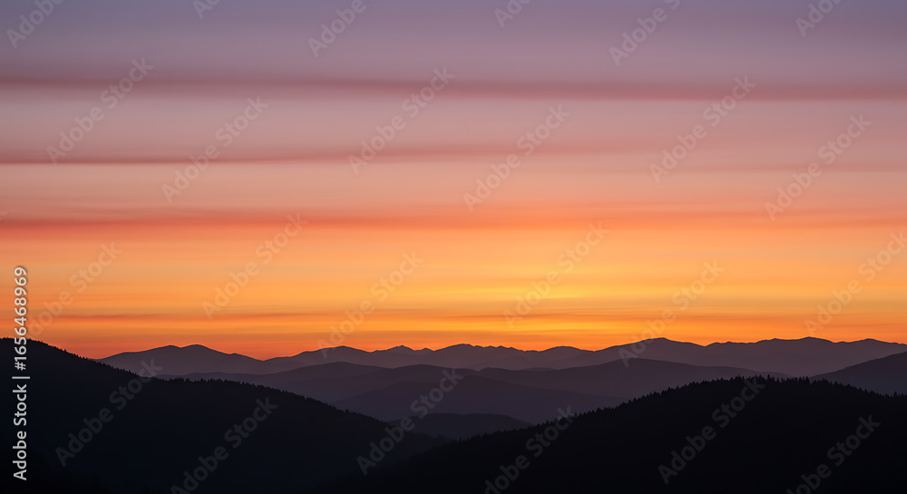 Obraz premium Stunning sunset over mountain range with vibrant orange and gold hues