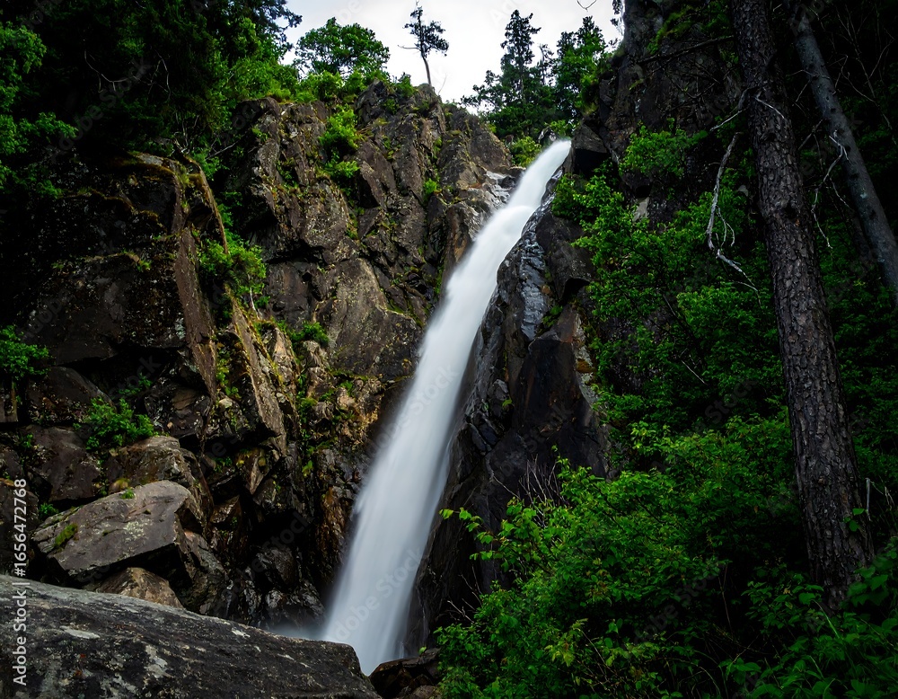 Obraz premium Waterfall cascading down rocky cliff face