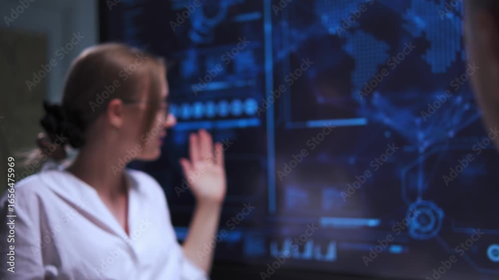 Young woman giving presentation in front of big screen in high-tech office Young woman giving presentation in front of big screen in high-tech office