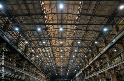Massive Industrial Warehouse Interior with Steel Framework and Grid Pattern Lighting