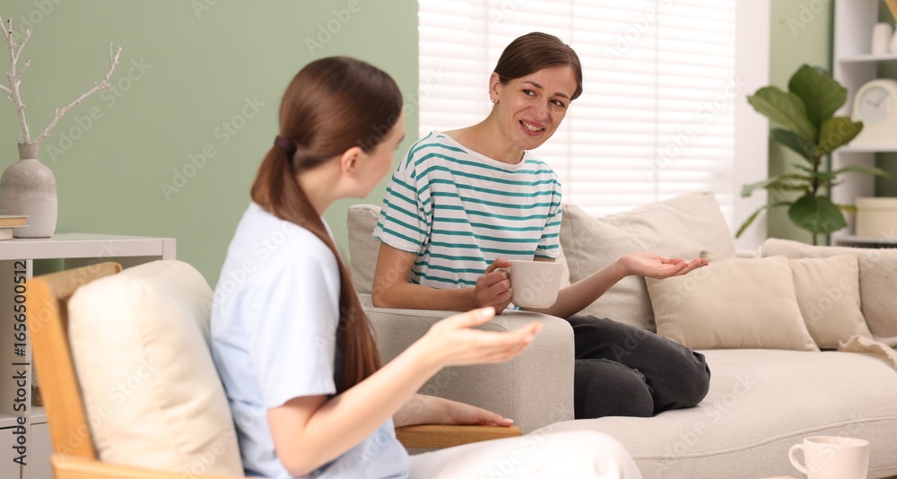 Obraz premium Friends talking while having tea at home