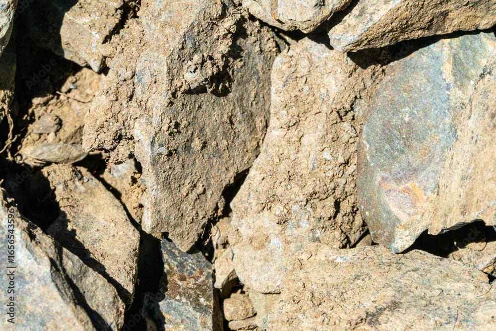 Fototapeta premium A close-up of the texture of rough, broken rock. The image captures the natural process of decay and weathering, ideal for use in environmental, geological or natural history work.