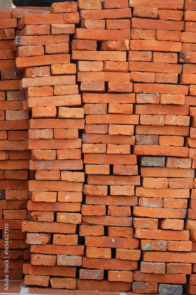 Obraz premium Tall rectangular construction brick pile stacked tightly in large vertical shape