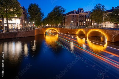 Amsterdam by night in the Netherlands, with canals, lights, reflections int the water