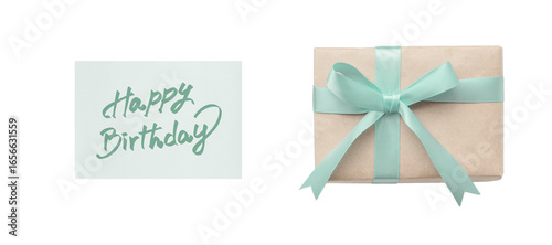 Overhead view of a green ribbon gift box and a happy birthday card with green handwritten lettering