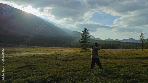 Hiker explores a serene landscape at sunset in a mountainous region surrounded by lush vegetation and natural beauty