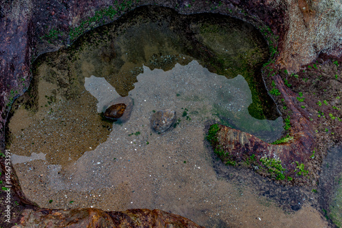 top view of small lake with calm, clean and clear water at edge of a mountain