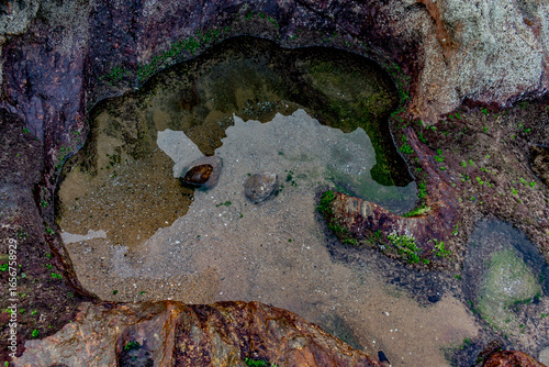 top view of small lake with calm, clean and clear water at edge of a mountain