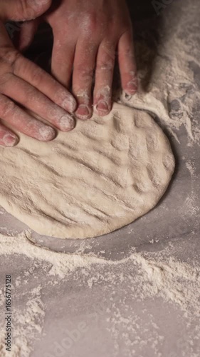The image captures the act of flattening dough on a clean work surface, highlighting the meticulous process involved in preparing fresh baked goods with care, fa01
