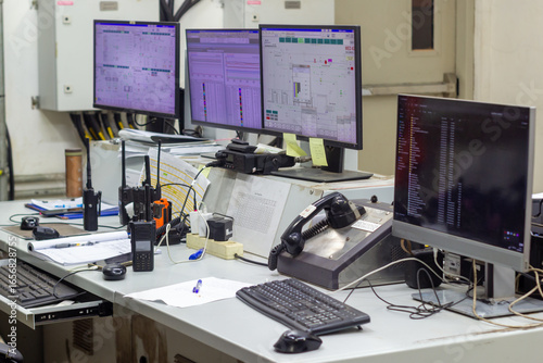 Control Room Operations Desk with Multiple Monitors and Radios