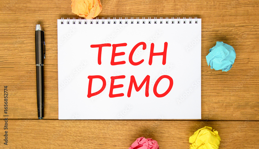 Fototapeta premium Tech demo symbol. Concept word Tech demo on beautiful white note. Black pen, colored paper. Beautiful wooden background. Business tech demo concept. Copy space.