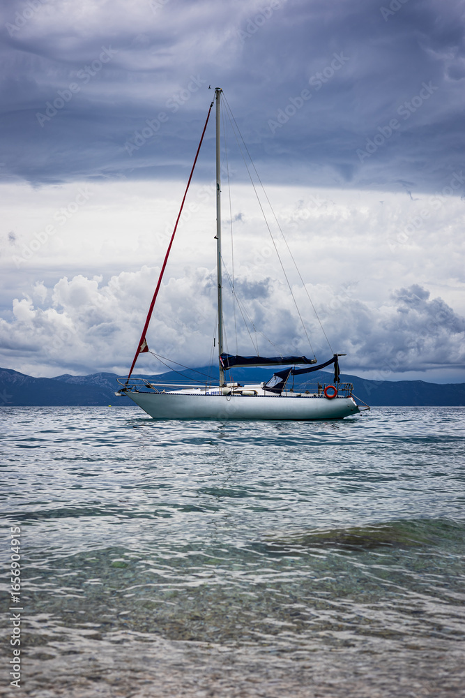 Fototapeta premium Sailboat off the coast with dramatic clouds in the background. Adriatic Sea, Croatia