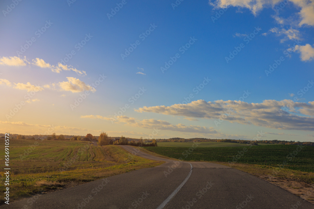 Fototapeta premium Autumn landscape and sunny evening, orange road and highway, asphalt and roadside.