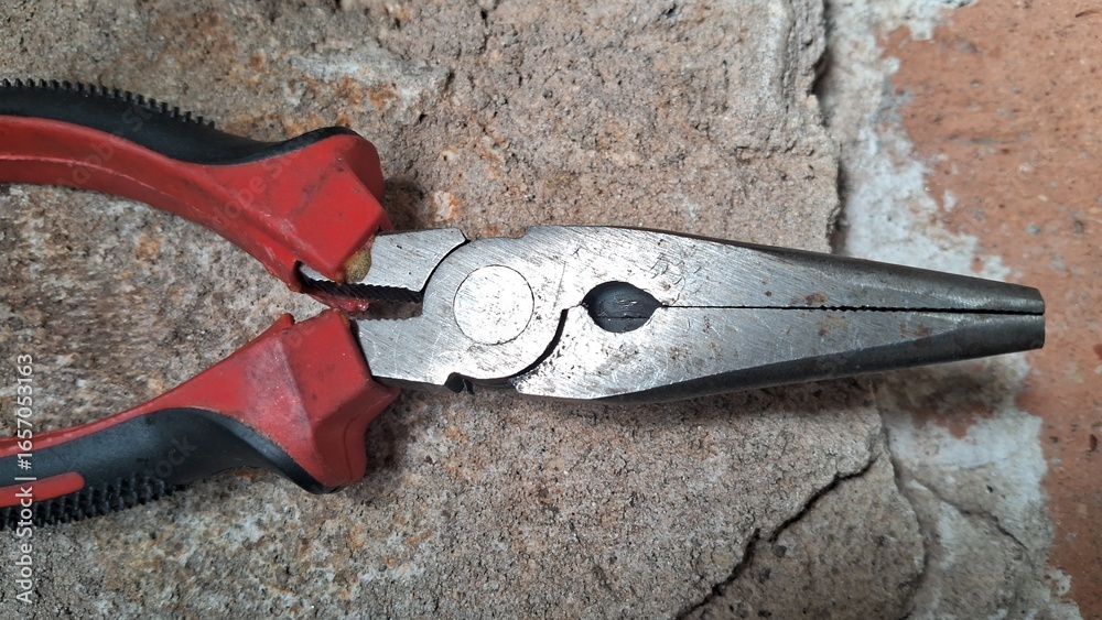 Obraz premium Close-up of a red and black needle-nose pliers tool