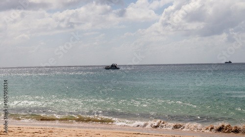 Embarcação distante no mar destaca paisagem oceânica e atmosfera tranquila do litoral tropical brasileiro.