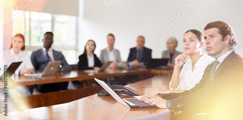 Картината върху платно Absorbed mature white dark-haired business man in formal suit sitting with his y