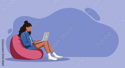 Young woman working or studying on a laptop from home, sitting comfortably on a bean bag chair. Concept of remote work, online learning, and flexible lifestyle.
