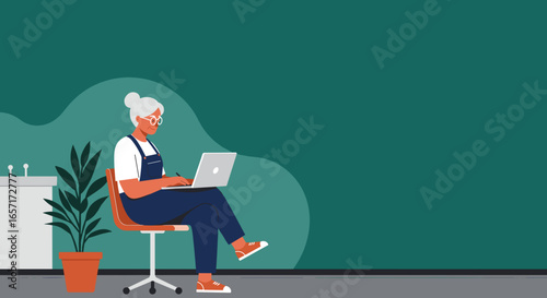 Happy senior woman in glasses and overalls actively using a laptop at home, embodying lifelong learning, remote work, and modern digital lifestyle.