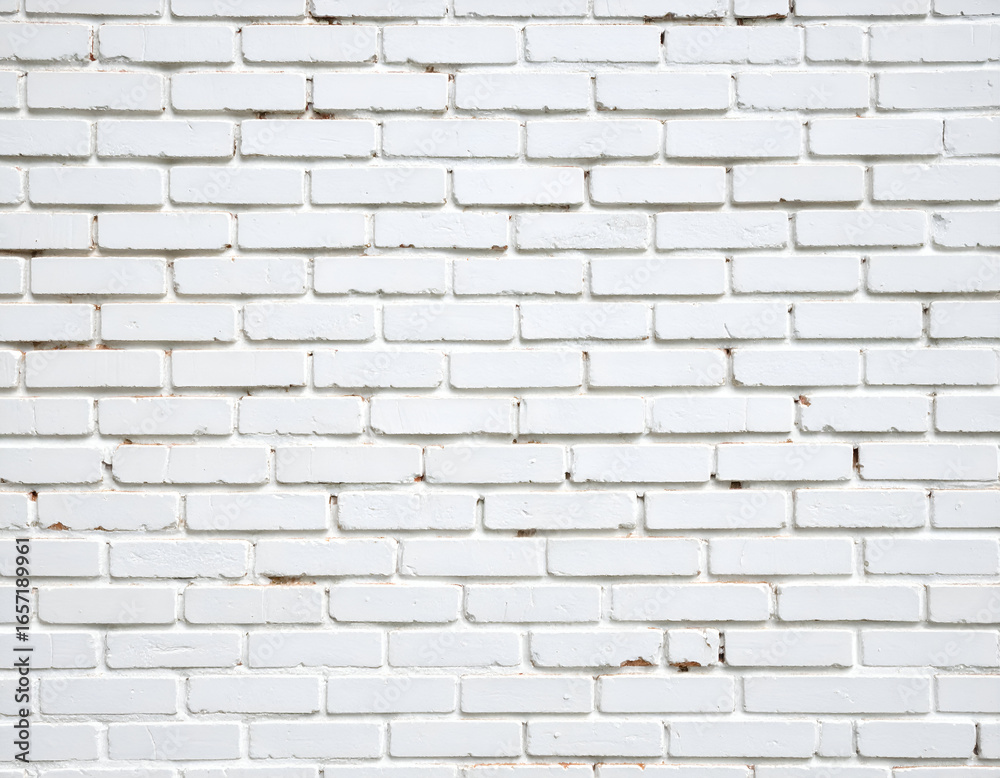 Naklejka premium A detailed full-frame shot of a white painted brick wall, showcasing its textured surface and subtle distressed elements, ideal for backgrounds or copy space.