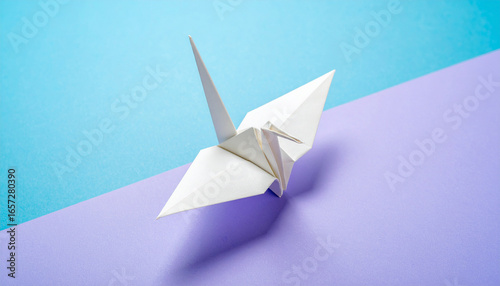 Origami Crane Serenity: A perfectly folded origami crane rests delicately, its crisp white form standing out against a backdrop of soft purple and blue hues, invoking a sense of peace and tranquility.