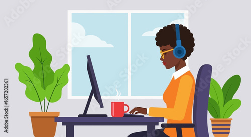 African American woman working remotely on a computer with headphones in a bright home office, perfect for business, education, or communication.