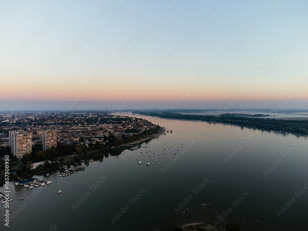 Fototapeta premium Aerial sunrise view over Belgrade city, river bend and urban skyline at golden light. g.