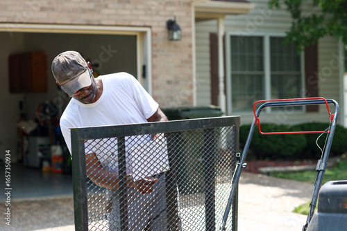 Fényképezés a portrait of a black man attaching a license plate to a trailer