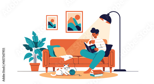 A person relaxing on a sofa reading a book while their cat plays nearby in a cozy living room setting