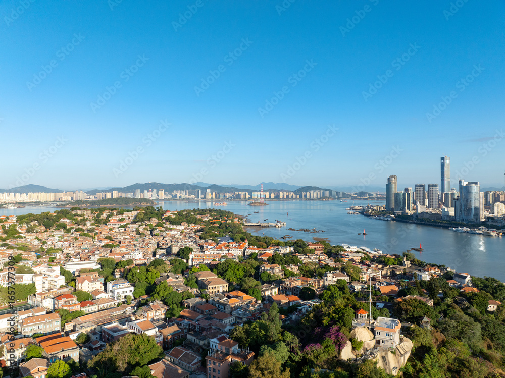 Obraz premium Panoramic view of the beautiful coastal city of Xiamen in China, showing modern skyscrapers, traditional buildings, and a bustling harbor.