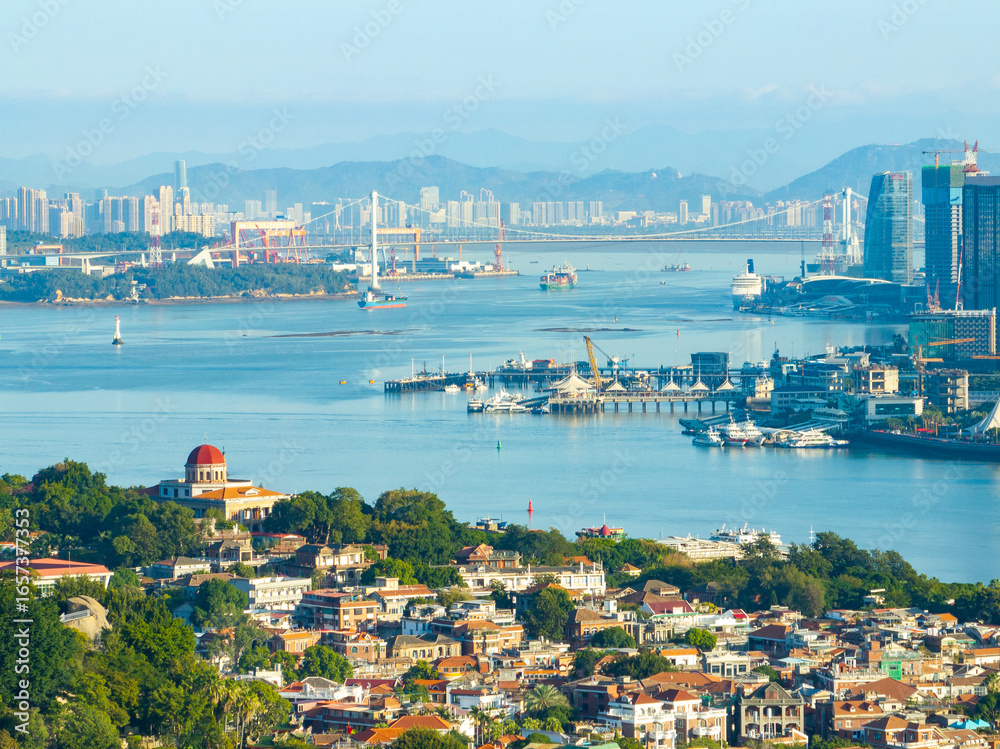 Obraz premium Xiamen China city showcases a dynamic blend of historic architecture and modern high rise buildings, all nestled along the busy sparkling waterfront.