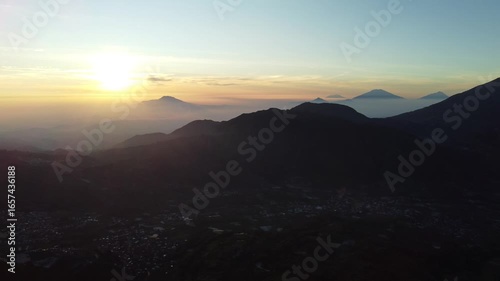 Sikunir Golden Sunrise, Indonesia, captured on August 19, 2025. Majestic golden light illuminating mountain peaks above a sea of clouds, with silhouettes of rolling hills and clear morning sky.