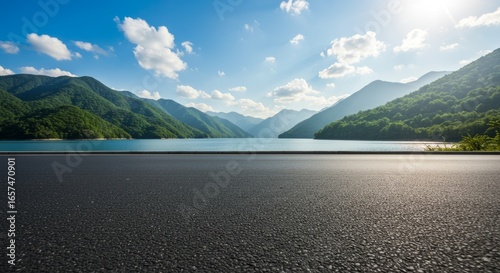 Lake view mountain landscape with asphalt road under blue sky mountain range horizon