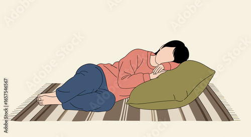 A person lies on a carpeted floor resting their head on a pillow while holding a phone