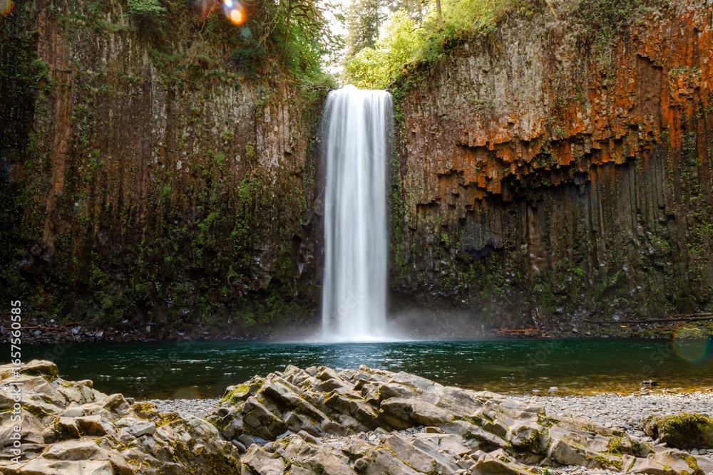 Fototapeta premium Waterfall cascading into serene pool
