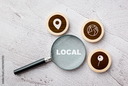 Fotografie Magnifying glass focusing on the word local with map icons around, concept of lo
