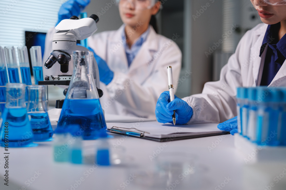 Fototapeta premium Scientist taking notes during experiment in laboratory