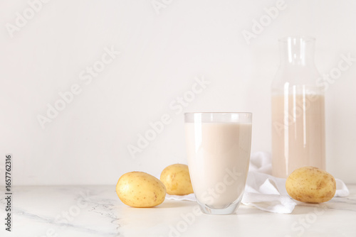 Potato milk in glass and bo...